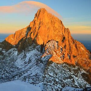 Pink cloud floats above Mt. Kenya during sunrise. Snow at the equator.